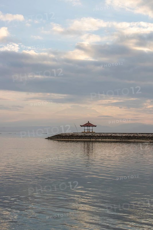 Beautiful seascape in the morning. Tropical sandy beach with breakwater and reflection of the sky in the calm water. Morning landscape, taken in Sanur, Bali, Indonesia, Asia