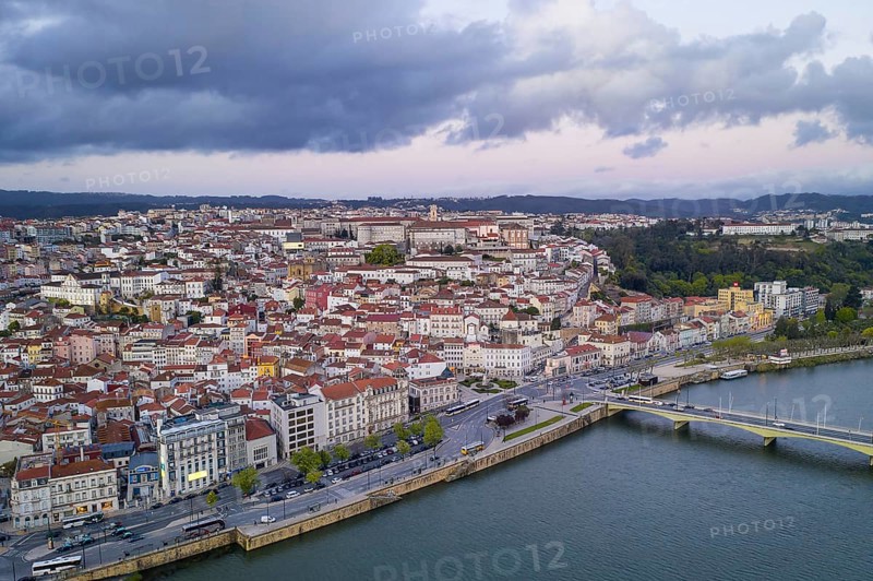 Coimbra drone aerial city view at sunset with Mondego river and beautiful historic buildings, in Portugal