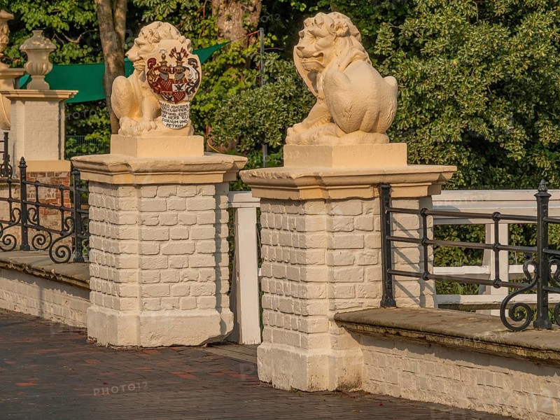 Detail of a historic parapet with lion statues, railings and white building elements, sunny atmosphere, dornum, east frisia, germany