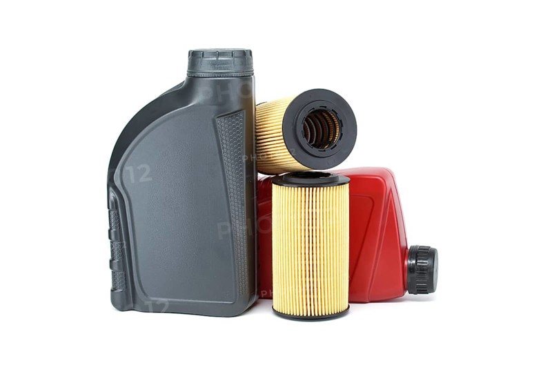 Motor oil filters elements oil and containers isolated on a white background. Car servicing, automotive industry and filter replacing maintenance