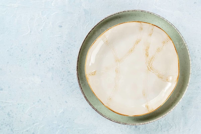 An empty plate with a gold rim, shot from above on a slate background with a place for text, Food photography