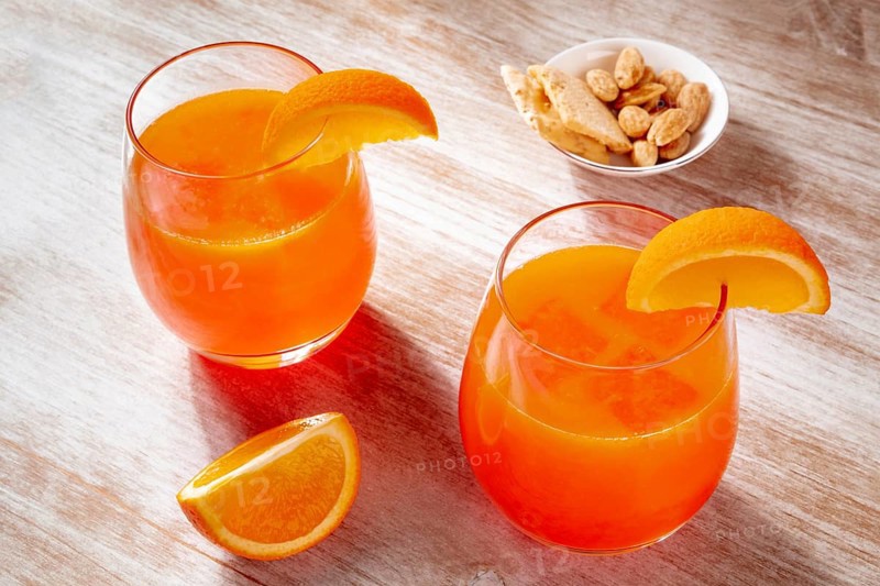 Orange drinks and a salty snack on a wooden background, fresh pressed juice with fruit slices on a rustic table, Food photography
