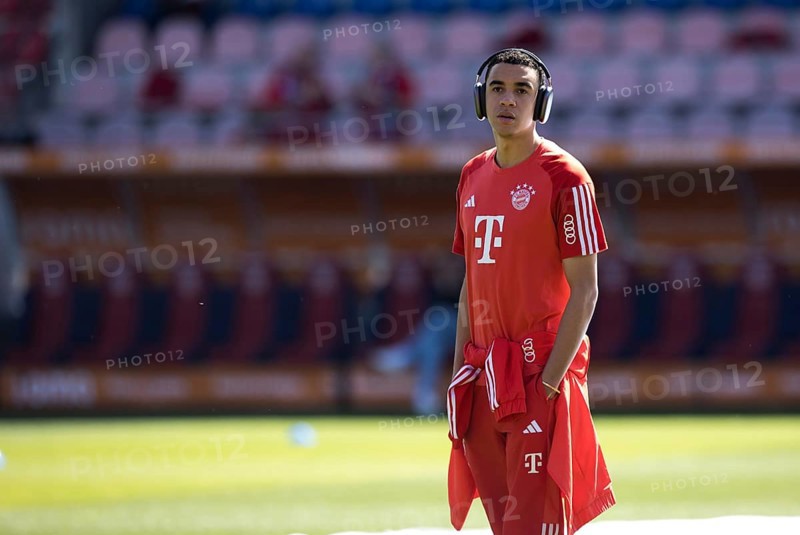 Jamal MUSIALA FC Bayern Munich with headphones and hands in pockets in front of the game
