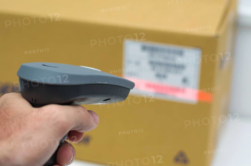 Great concept of traceability, ERP system, hand crawling product barcode and packaging. The man gets on the hip scanner in operations directed on printed barcode. Warehouse scene. Shallow DOF!