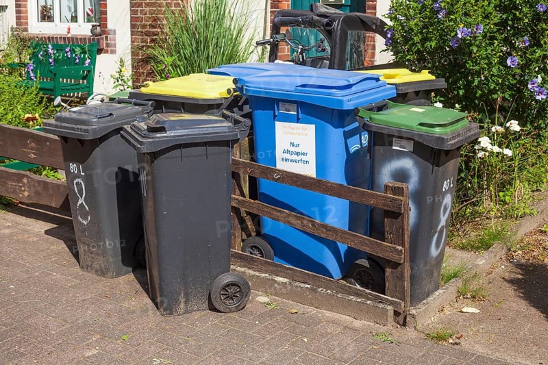 Colourful different dustbins standing in front of a house entrance, Delmenhorst, Lower Saxony, Germany, Europe