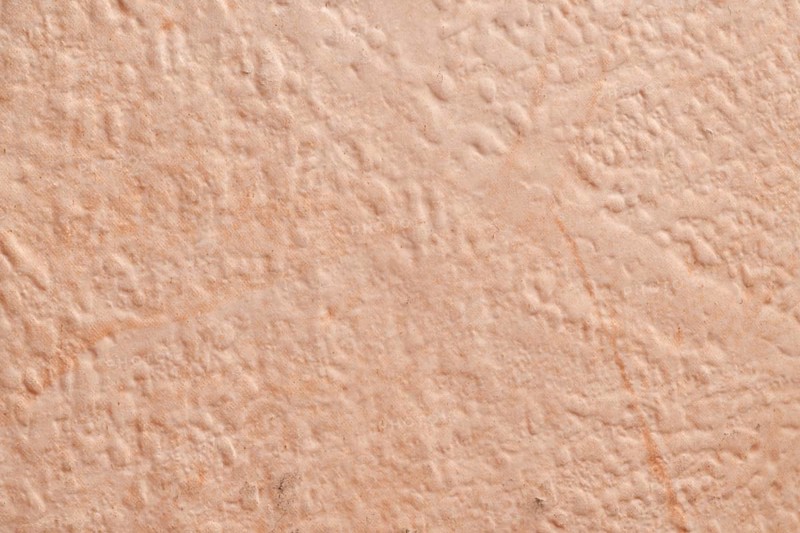 Light beige, roughly plastered house wall as full-format background
