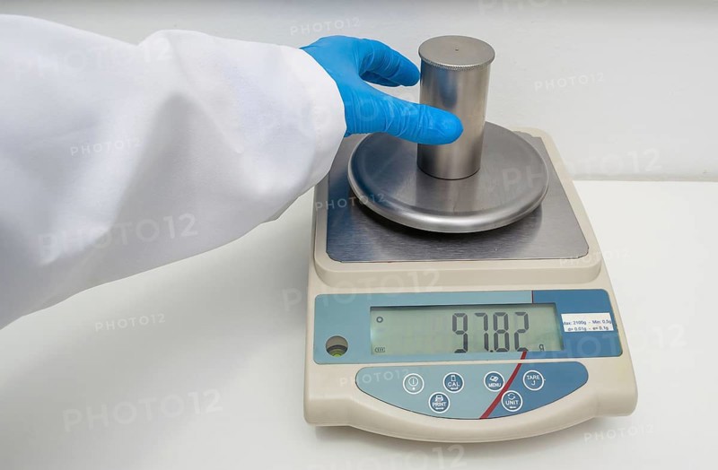 Great concept of research and development, hand measuring the density of a liquid with the pycnometer