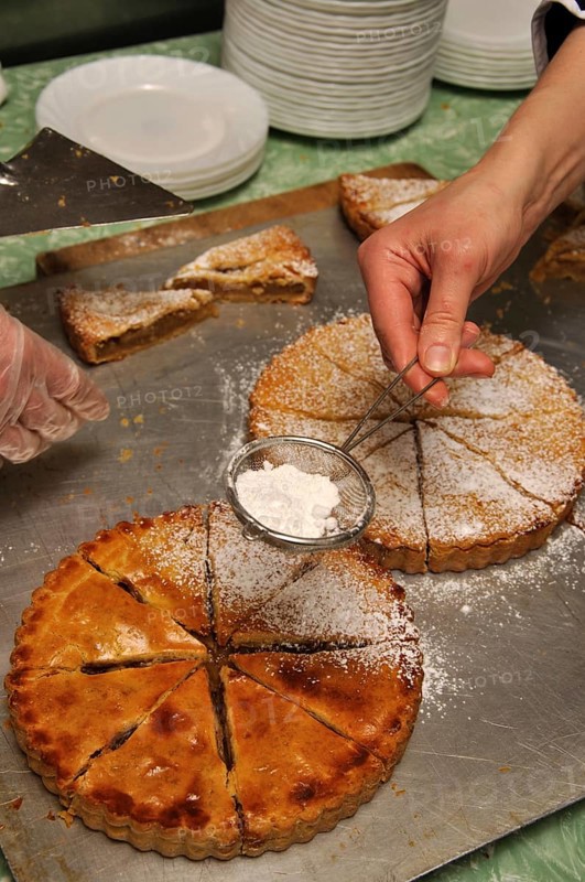 Cook sprinkling icing sugar on delicious homemade apple pies
