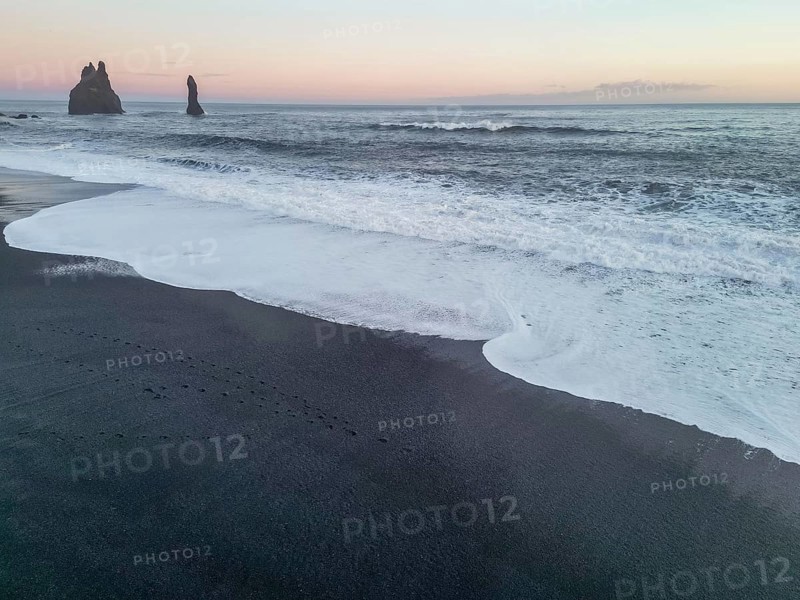 Aerial drone view of Reynisfjara black sand beach at sunset in Iceland