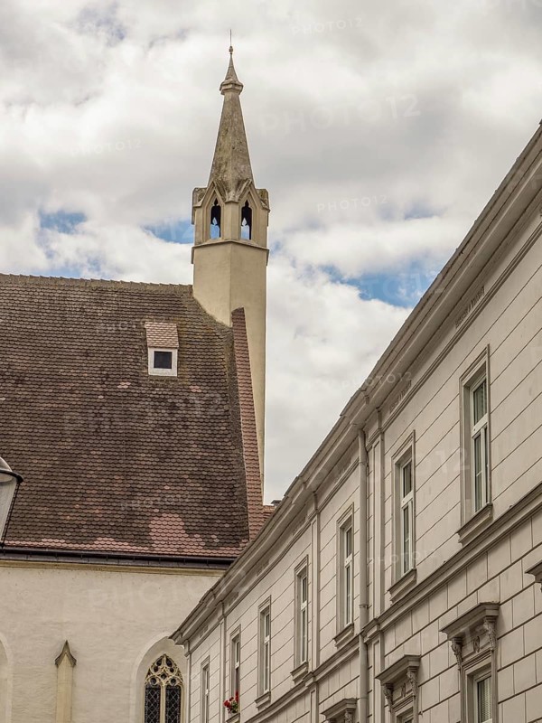 Historic building with a church in the background and a tower under a slightly cloudy sky, Dürnstein, Wachau, Danube, Austria, Europe