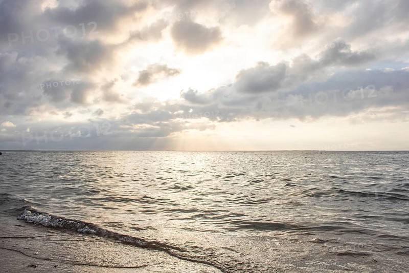 Beautiful seascape in the morning. Tropical sandy beach with breakwater and reflection of the sky in the calm water. Morning landscape, taken in Sanur, Bali, Indonesia, Asia