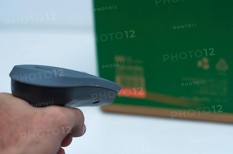 Great concept of traceability, ERP system, hand crawling product barcode and packaging. The man gets on the hip scanner in operations directed on printed barcode. Warehouse scene. Shallow DOF!