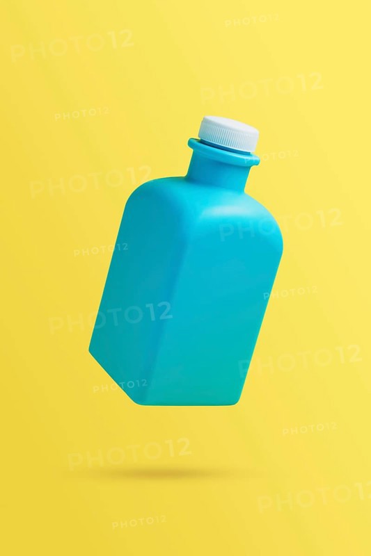 Levitation, flying blank cleaner blue bottle. Isolated on yellow background. Plastic packaging. Household chemicals. Falling in air single object. Laundry conditioner, soap washer or softener template