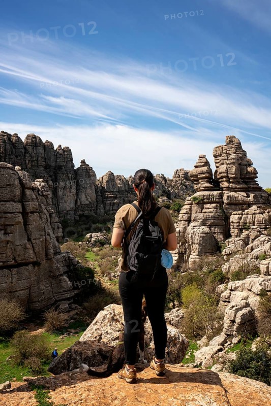 Woman looking at limestone rock formations in El Torcal de Antequera nature reserve, in Spain