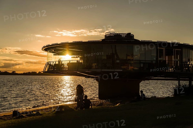 Porto Alegre, Rio Grande do Sul, Brazil, March 29, 2021: Panoramic restaurant on the Guaíba waterfront in silhouette at sunset, South America