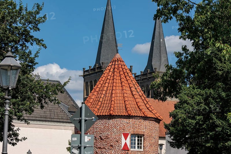 Historic brick building with striking towers and trees under a blue-green sky, Xanten, Lower Rhine, North Rhine-Westphalia, Germany, Europe