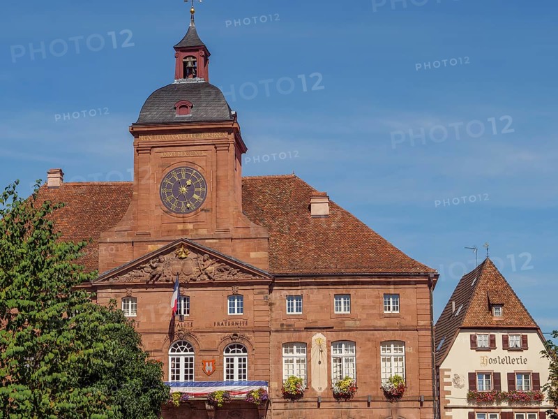 Building with historic façade, a clock and shutters under a clear sky, Weissenburg, Alsace, France, Europe