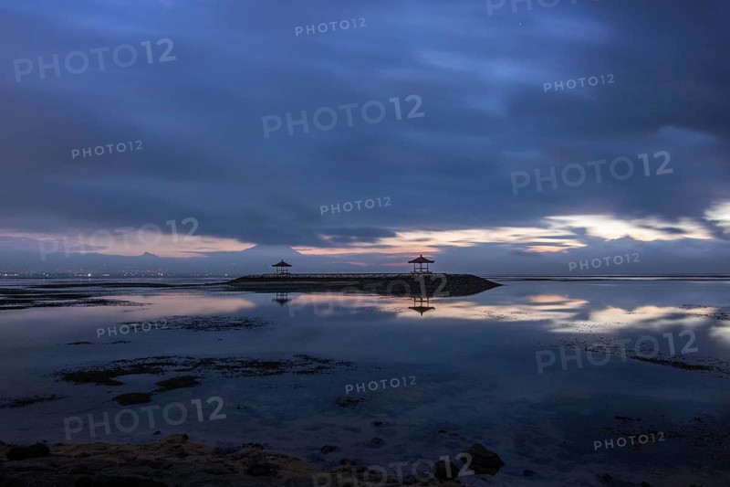 Beautiful seascape in the morning. Tropical sandy beach with breakwater and reflection of the sky in the calm water. Morning landscape, taken in Sanur, Bali, Indonesia, Asia