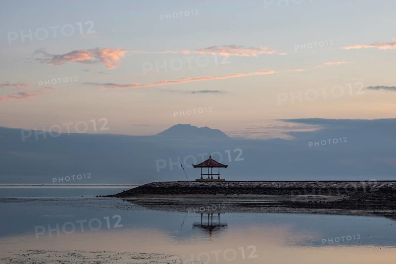 Beautiful seascape in the morning. Tropical sandy beach with breakwater and reflection of the sky in the calm water. Morning landscape, taken in Sanur, Bali, Indonesia, Asia