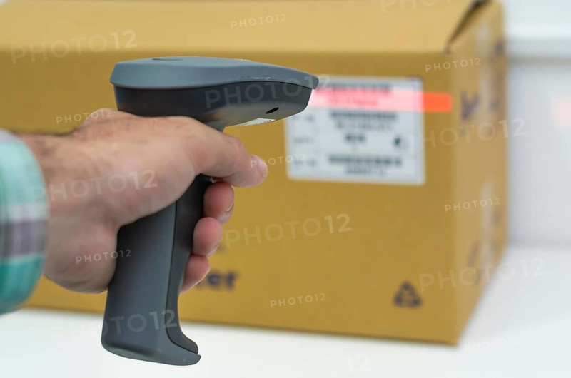 Great concept of traceability, ERP system, hand crawling product barcode and packaging. The man gets on the hip scanner in operations directed on printed barcode. Warehouse scene. Shallow DOF!