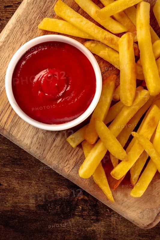 French fries, potato snack with ketchup, fast food on a wooden table, shot from the top with a place for text, Food photography