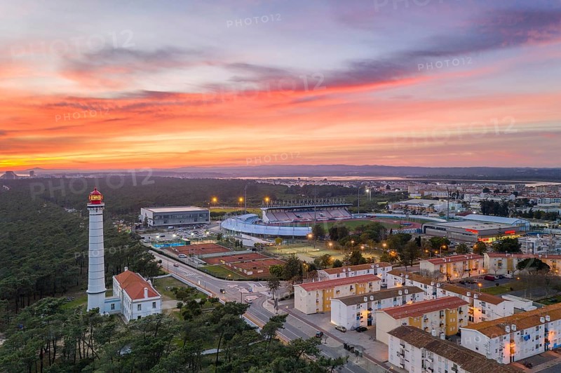 Aerial drone view of Vila Real de Santo Antonio city, lighthouse farol and stadium in Portugal, at sunset