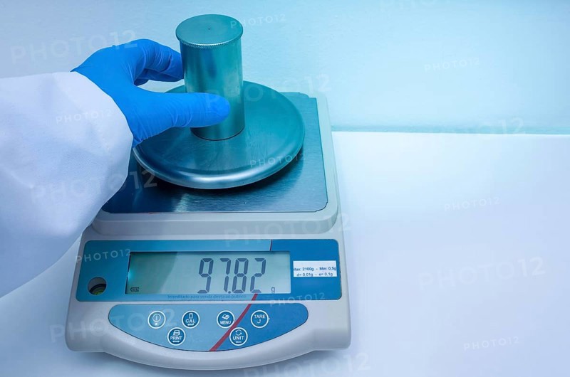 Great concept of research and development, hand measuring the density of a liquid with the pycnometer