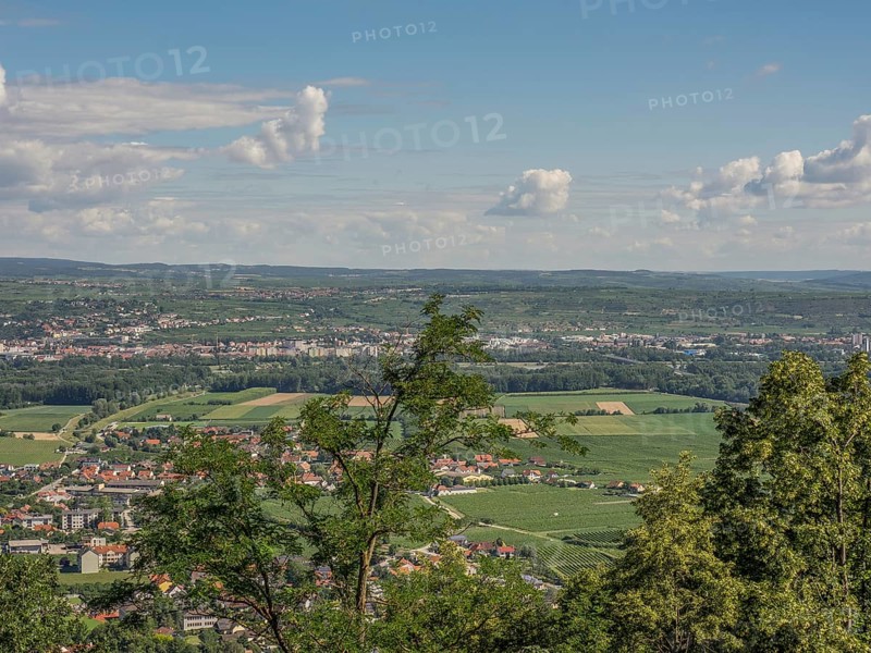 A wide view of a town and fields, surrounded by trees and clouds in the sky, Dürnstein, Wachau, Danube, Austria, Europe