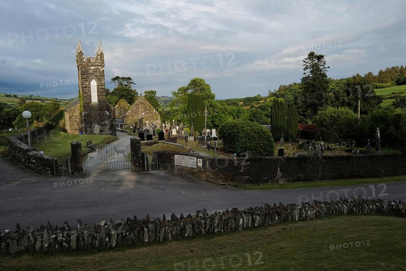 A view of the Church and graveyard near St Gobnait's well in Cúil Aodha in West Cork on a sunny evening. County Cork, Ireland, Europe