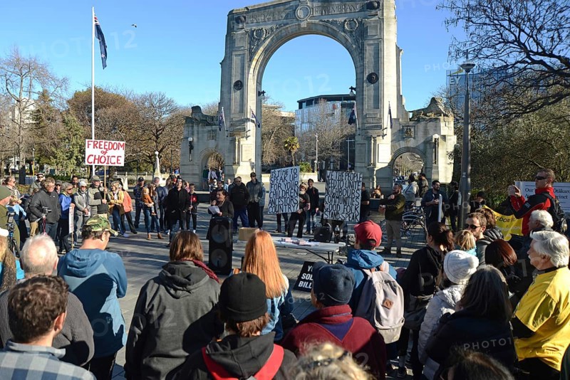 CHRISTCHURCH, NEW ZEALAND, JULY 24, 2021, People gather at a protest rally at the Bridge of Remembrance in Christchurch. Activists spoke against increasing government control over Covid vaccinations, farm taxes and civil liberties