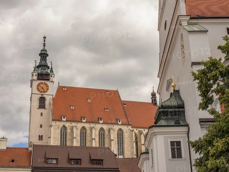 Gothic church with clock tower and neighbouring building under a cloudy sky, Dürnstein, Wachau, Danube, Austria, Europe