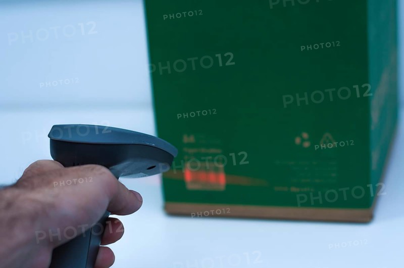 Great concept of traceability, ERP system, hand crawling product barcode and packaging. The man gets on the hip scanner in operations directed on printed barcode. Warehouse scene. Shallow DOF!