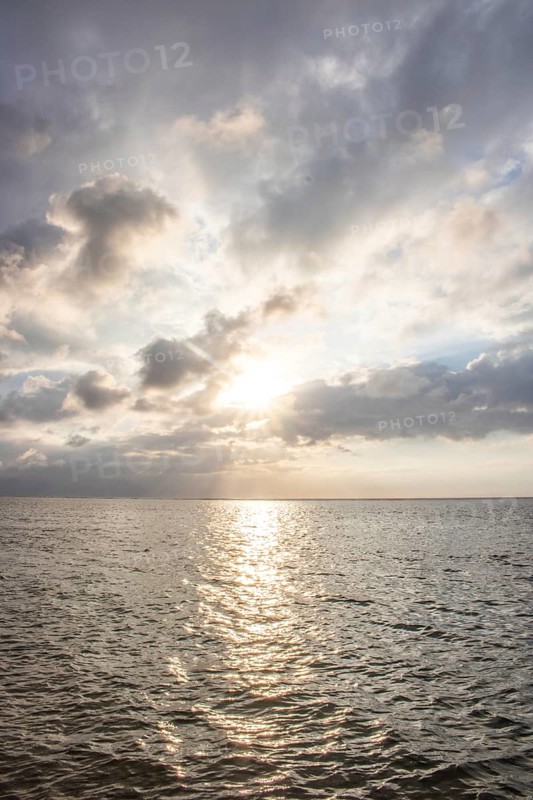 Beautiful seascape in the morning. Tropical sandy beach with breakwater and reflection of the sky in the calm water. Morning landscape, taken in Sanur, Bali, Indonesia, Asia
