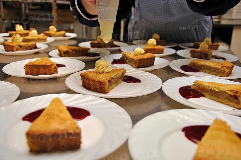 Cooks adding cream to delicious homemade apple pies