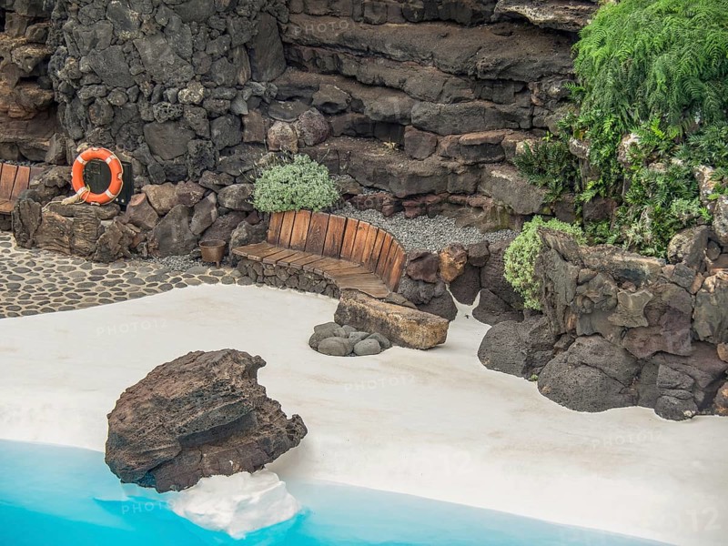 White sand with rocks, a blue pool, bench and lifebuoy, lanzarote, Canary Islands, Spain, Europe
