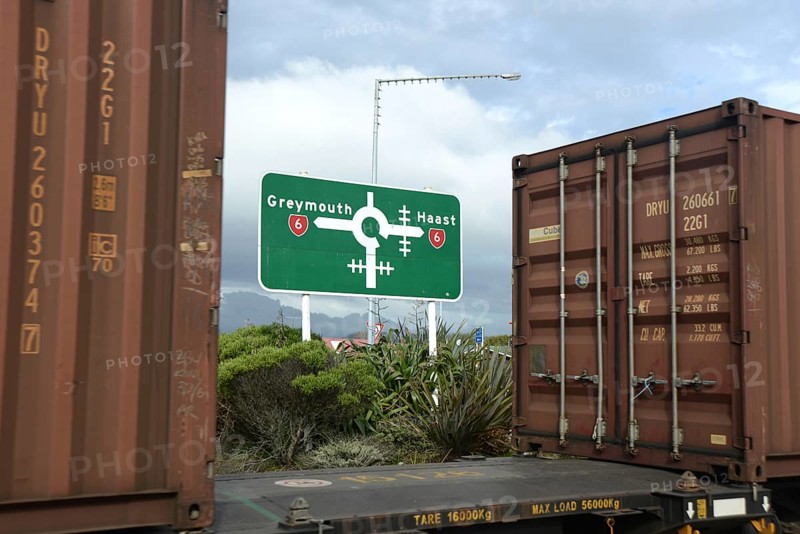 HOKITIKA, NEW ZEALAND, AUGUST 29, 2020: A freight train crosses the main street of Hokitika near the roundabout on State Highway 6