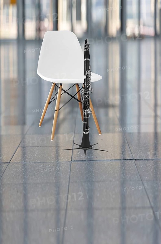 Clarinet and a white chair in an auditorium