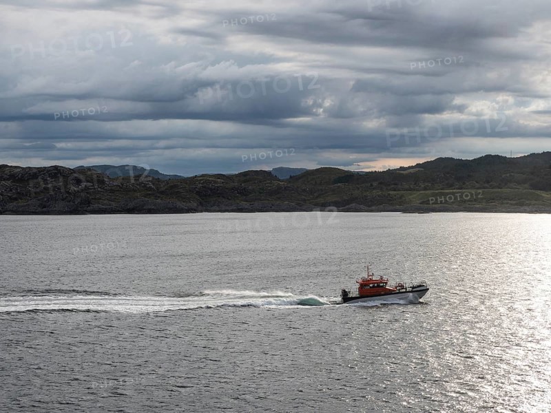 A pilot boat sails along the Norwegian coast