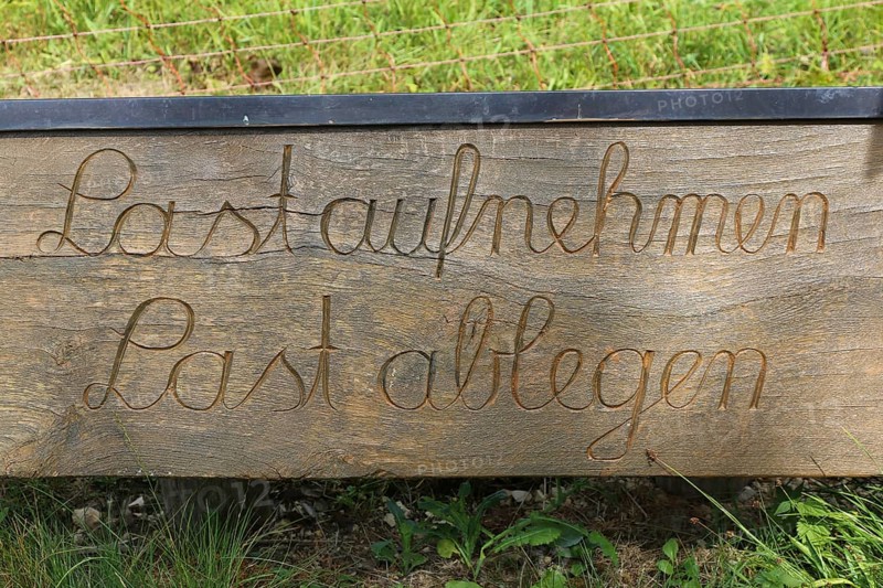 Station trail in Altstreußlingen, cursive writing, take up a burden, lay down a burden, theme trail, circular tour, hiking trail, part of the paths of reflection and contemplation in the Ehinger Alb, Altstreußlingen, Swabian Alb, Baden-Württemberg, Germany, Europe