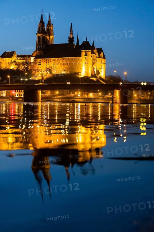 The Elbe in Meissen is slightly high water after the snow has melted, the Burgberg is reflected in the river at blue hour