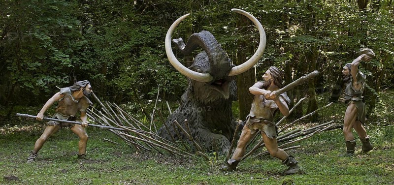 Diorama showing Neanderthal hunters killing trapped prehistoric mammoth at Prehisto Parc, theme park about prehistoric life at Tursac, Périgord, Dordogne, France, Europe