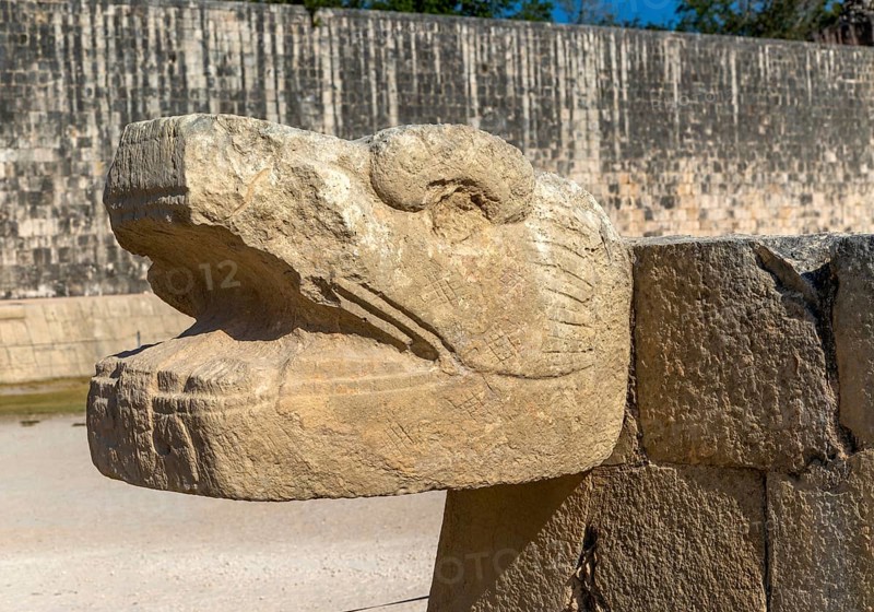 Carved stonework jaguar head with walls of the ball court, Juego de Pelota, Chichen Itzá, Mayan ruins, Yucatan, Mexico, Central America