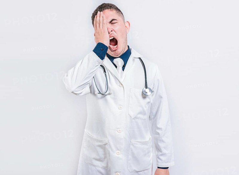Sleepy doctor yawning on isolated background. Tired of working doctor concept, Tired and sleepy doctor isolated