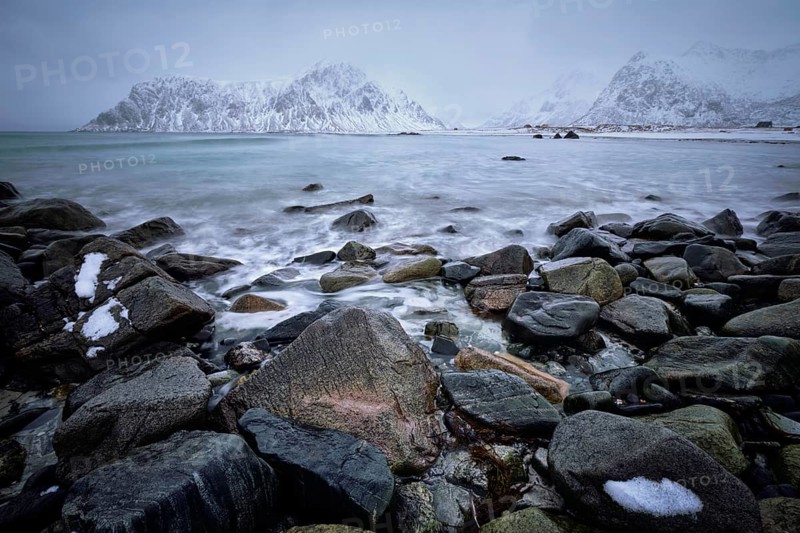 Waves and rocks on coast of Norwegian sea in fjord. Skagsanden beach, Flakstad, Lofoten islands, Norway. Long exposure motion blur