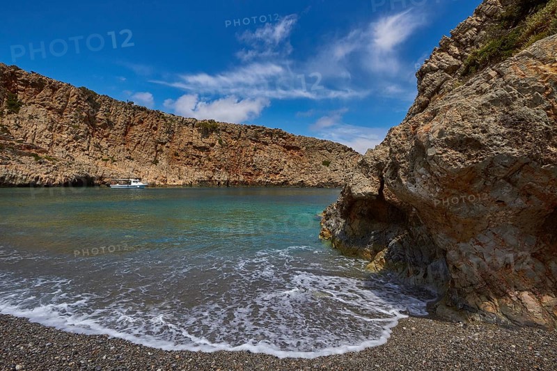 Menies, Rodopou, dream bay, single boat at anchor, spray, rocks, pebble beach, crystal clear sea, green sea, turquoise sea, blue sea, Doric archaeological site, sanctuary of Diktynna, blue sky with white clouds, Rodopou peninsula, West Crete, island of Crete, Greece, Europe