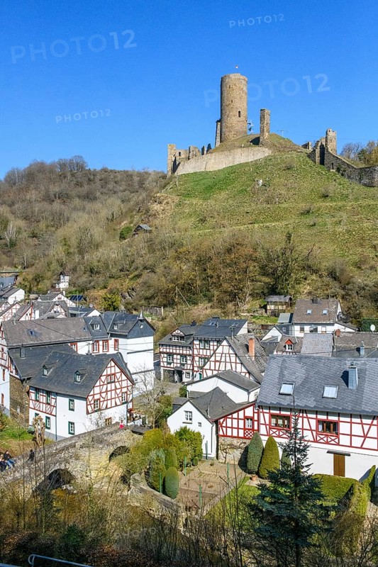 View of Löwenburg ruins, in the foreground ruins of old fortified defence tower, behind Lower bridge over river Elz Elzbach and half-timbered houses, Monreal, Eifel, Rhineland-Palatinate, Germany, Europe