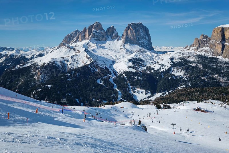 View of a ski resort piste with people skiing in Dolomites in Italy. Ski area Belvedere. Canazei, Italy, Europe