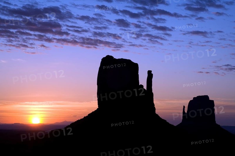Eroded sandstone rock formations, buttes the Mittens silhouette at dawn in Monument Valley Navajo Tribal Park, Arizona, USA, North America
