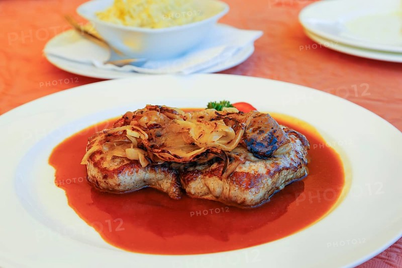 Swabian cuisine, roast onions, sautéed onions, roast beef with roasted onions, roast beef, beef, traditional main course, hearty, sauce, gravy, typical Swabian, hearty home cooking, plate, traditional cuisine, food photography, studio, Germany, Europe
