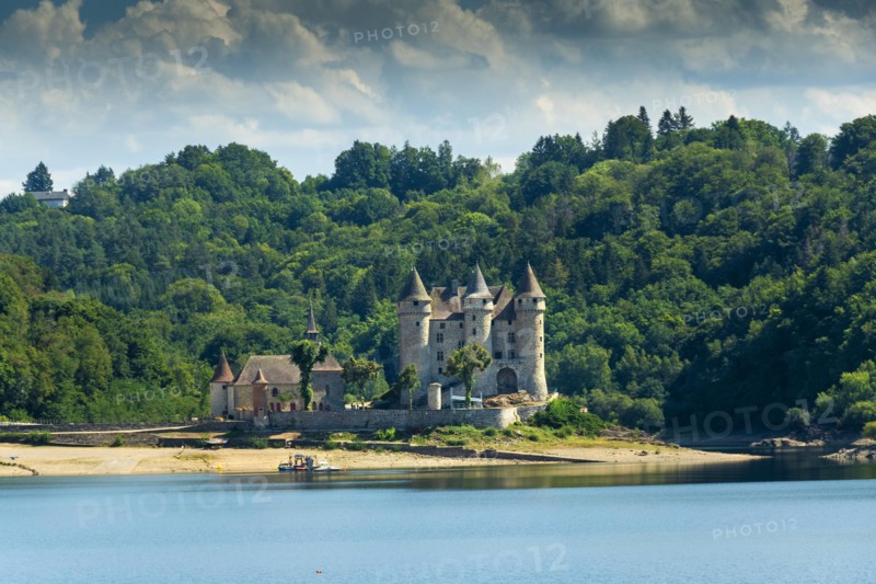 Lanobre. Chateau de Val from the 13th century, which has been modified several times, is situated on the waters of the Bort dam. Cantal department. Auvergne Rhone Alpes. France